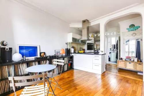 une grande cuisine avec une table et un comptoir dans l'établissement Comfort and tranquility near the Canal de l Ourcq, à Paris