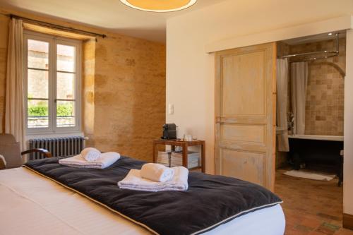 a bedroom with a bed with two towels on it at Les Hauts de Saint Vincent B&B proche Sarlat in Saint-Vincent-de-Cosse