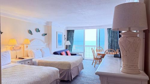 a hotel room with two beds and a balcony at Breathtaking OCEAN FRONT Condo in Daytona Beach in Daytona Beach