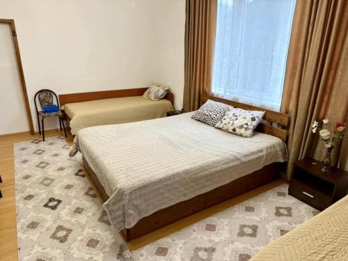 a bedroom with two beds and a window at Guest House Mihalkovo in Mikhalkovo