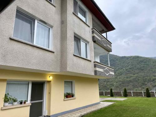 a building with windows and a mountain in the background at Guest House Mihalkovo in Mikhalkovo
