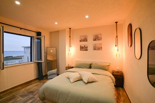 a bedroom with a large bed and a large window at Isula SeaView Apartments in Isola delle Femmine