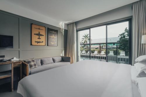 ナイヤンビーチにあるSugar Marina Hotel -AVIATOR- Phuket Airportのベッドルーム(大型ベッド1台、窓付)