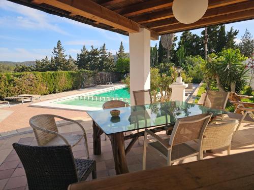 eine Terrasse mit Tisch und Stühlen und einem Pool in der Unterkunft Villa Can Ripoll in Ibiza-Stadt