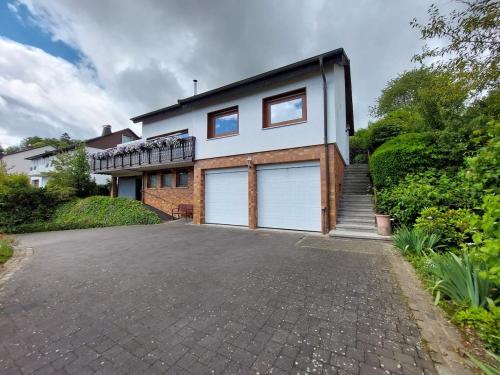 a house with two garage doors on a driveway at gemütliche Dachgeschoss- Ferienwohnung im Grünen in Sundern