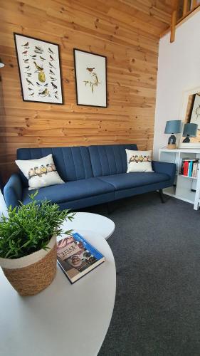 a living room with a blue couch and a table at Babie Lato b&b in Uniejow