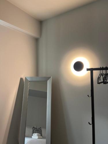 a bathroom with a mirror and a light on the wall at ALTHEA luxury suites and apartments in Plataria