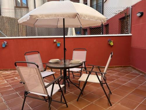 a table and chairs with an umbrella on a patio at Exclusive apartment with a terrace in Mora de Rubielos