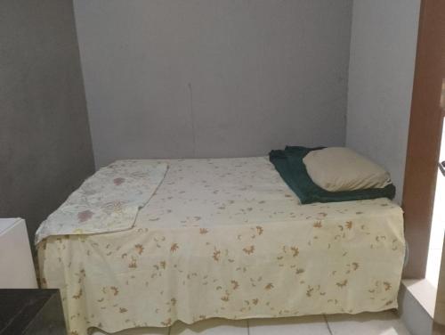 a small bedroom with a bed with a blanket on it at Hostel vila nova in Niterói