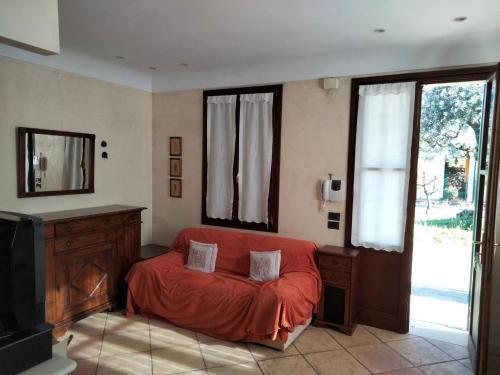 a living room with a red bed and a mirror at Casa Sandra in Montegrotto Terme