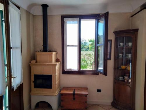 a living room with a stove and a window at Casa Sandra in Montegrotto Terme