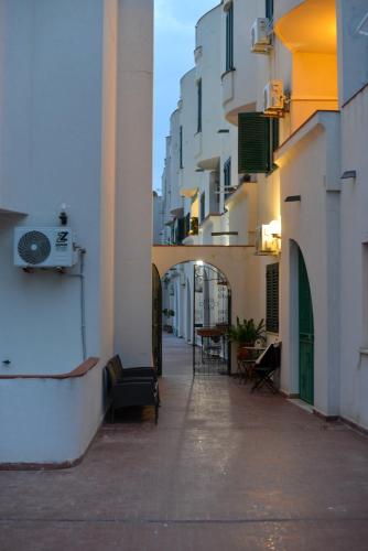an alley between two buildings with chairs and tables at Isula SeaView Apartments in Isola delle Femmine