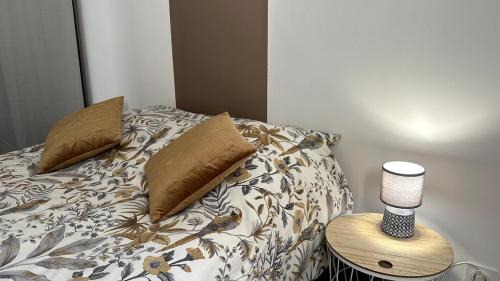 - un lit avec des oreillers et une lampe sur une table dans l'établissement Maison 4 pers - Jardin et calme, à Arles