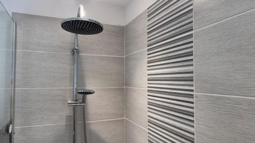 une douche dans une salle de bain avec une porte vitrée dans l'établissement Maison 4 pers - Jardin et calme, à Arles