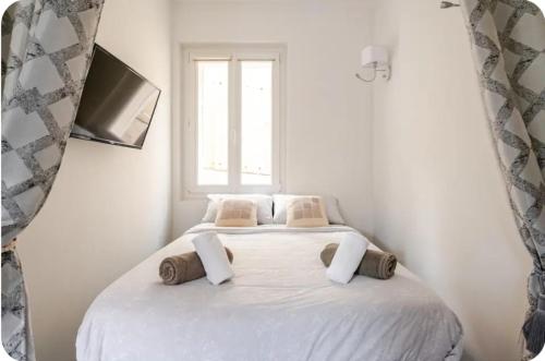 une chambre avec un grand lit blanc avec une fenêtre dans l'établissement Appartement Cannes Centre Ville Croisette, à Cannes