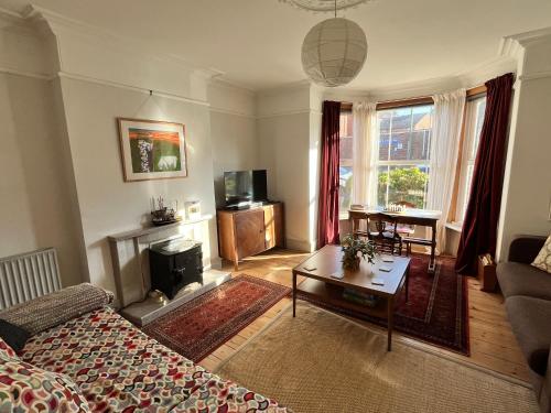 a living room with a couch and a table at Augusta garden apartment in Sheringham