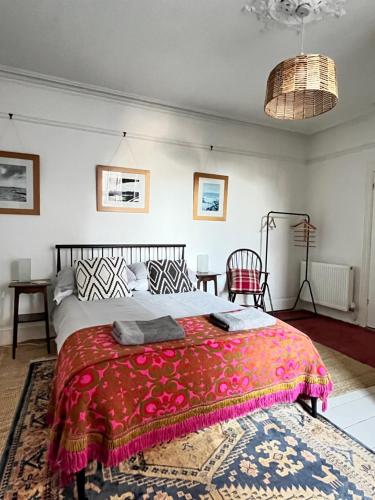 a bedroom with a large bed with a red blanket at Augusta garden apartment in Sheringham