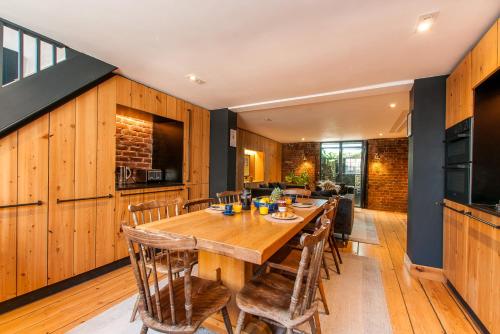 a dining room with a wooden table and chairs at Opulent Georgian townhouse overlooking Spencer Square in Kent