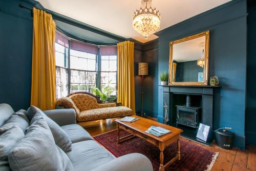a living room with a couch and a fireplace at Opulent Georgian townhouse overlooking Spencer Square in Kent