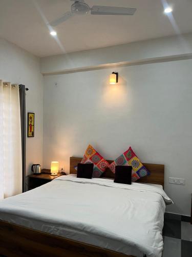 a bedroom with a white bed with pillows on it at Hidden Lake By Vista Stays in Bhīm Tāl