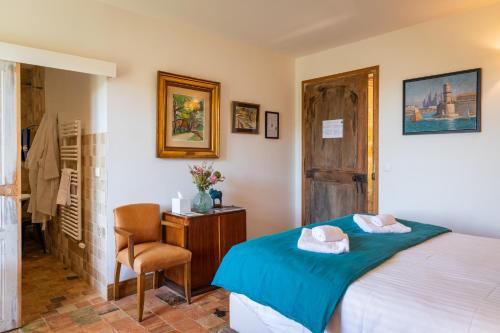 a bedroom with a bed and a chair and a desk at Les Hauts de Saint Vincent B&B proche Sarlat in Saint-Vincent-de-Cosse