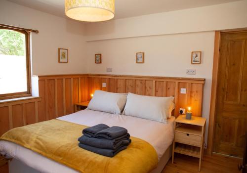 a bedroom with a bed with two towels on it at The Barn - Brynberian, Eglwyswrw in Eglwyswrw