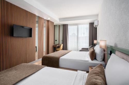a hotel room with two beds and a flat screen tv at Sun Heaven Queen in Alanya