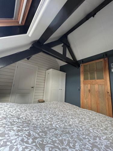 a bedroom with a bed and a wooden door at Heikant Hoeve met Jacuzzi in Baarle-Nassau
