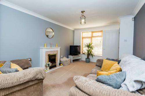 a living room with two couches and a fireplace at Modern 3 Bedroom Home in Swindon with Parking in Swindon