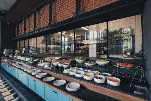 a buffet line with many plates of food on it at Sugar Marina Hotel -AVIATOR- Phuket Airport in Nai Yang Beach