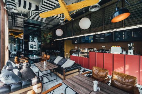 a restaurant with couches and tables and chairs at Sugar Marina Hotel -AVIATOR- Phuket Airport in Nai Yang Beach