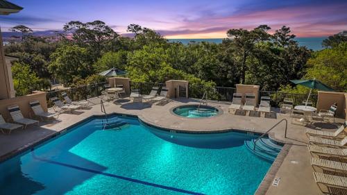 a large swimming pool with chairs at Near Beach & Coligny Plaza, Pool, Hot Tub, Patio in Hilton Head Island