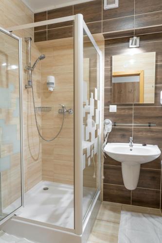 a bathroom with a shower and a sink at Hotel Toliar & wellness in Štrbské Pleso