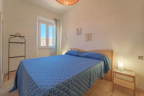 ein Schlafzimmer mit einem blauen Bett und einem Fenster in der Unterkunft Nel cuore di Rio Marina in Rio Marina