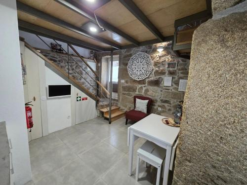 a living room with a table and a stone wall at Beautiful home in the countryside in Sernancelhe