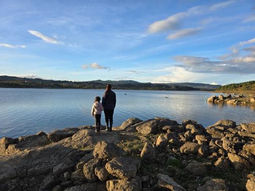 a man and a child standing on rocks by the water at Beautiful home in the countryside in Sernancelhe