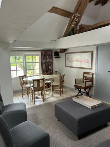 un salon avec une table et des chaises dans l'établissement Le Petit Moulin, à Lusigny-sur-Ouche
