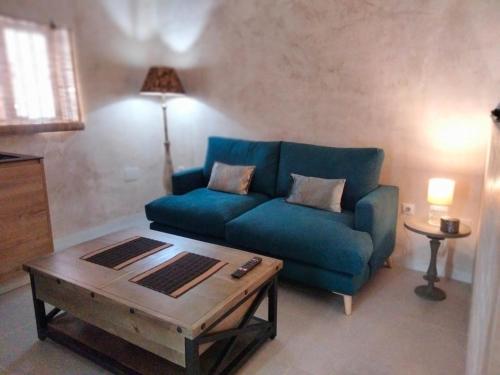 a living room with a blue couch and a coffee table at Verde Oliva loft in Vejer de la Frontera