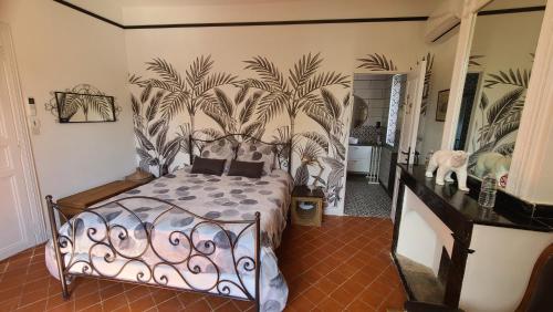 a bedroom with a bed with a mural of palm trees at Le N 9 in Argeliers