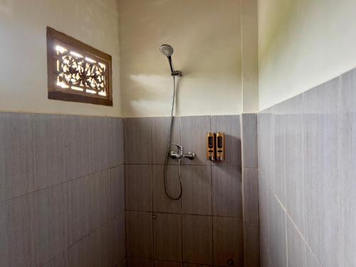 a bathroom with a shower with a shower head at Pesona 361 Alam Bungalows in Rarang