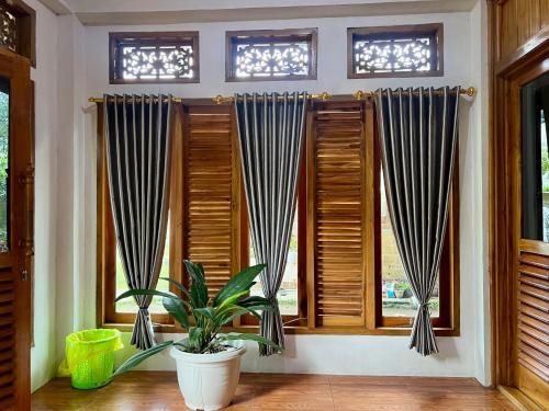 a room with wooden windows and a potted plant at Pesona 361 Alam Bungalows in Rarang