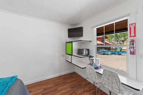 a living room with a table and chairs and a tv at Atomic Motel in Moab