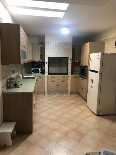 a large kitchen with a refrigerator and a tv at Casa Sara in Monopoli