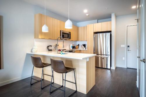 a kitchen with a counter and two bar stools at Luxury Apt Downtown in White Plains