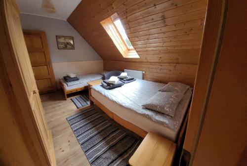a room with two beds in a wooden cabin at Dom pod Wilczyńcem in Stronie Śląskie