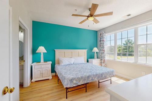 a blue bedroom with a bed and a ceiling fan at Palmy Days @ Ironwood 424 in Myrtle Beach
