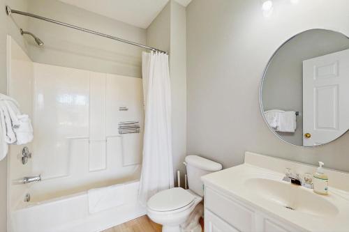 a bathroom with a toilet and a sink and a mirror at Palmy Days @ Ironwood 424 in Myrtle Beach