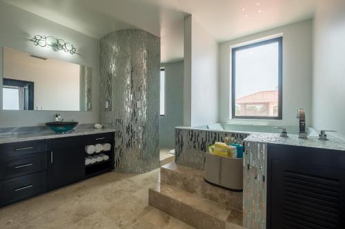 a bathroom with a sink and a large mirror at Diamante Beachfront Suites in San Pedro