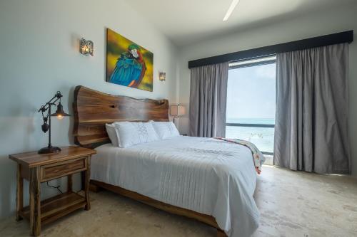 a bedroom with a bed and a large window at Diamante Beachfront Suites in San Pedro