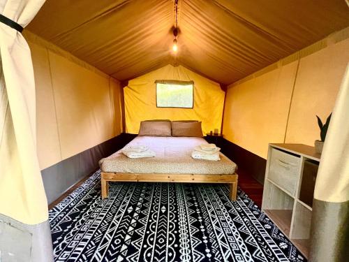 a small bedroom with a bed in a tent at CAMPING AMALASUNTA in Montefiascone